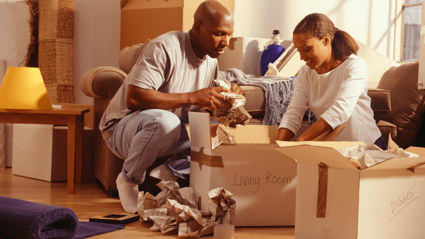 A couple unpacking boxes together in a warm, cozy living room