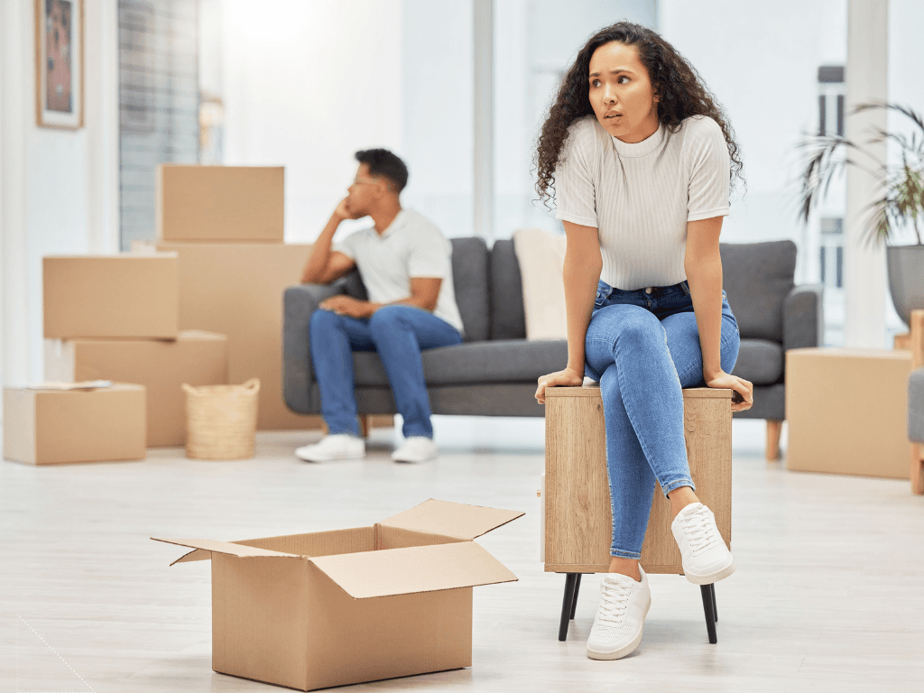 A woman sitting on a moving box taking a break amid the move